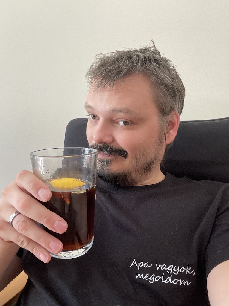 Apa vagyok, megoldom feliratú pólóban ülök egy pohár itallal a kanapén!